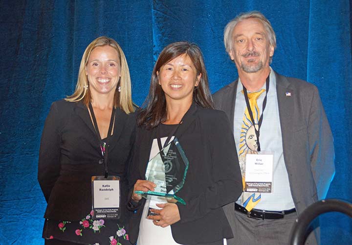 Huyen Dinh stands with her award plaque between Katie Randolph and Eric Miller.