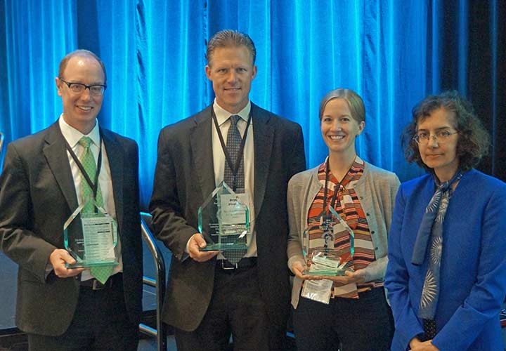 Mark Ruth, Bryan Pivovar, and Paige Jadun pose with their award plaques in a group photo with Sunita Satyapal.